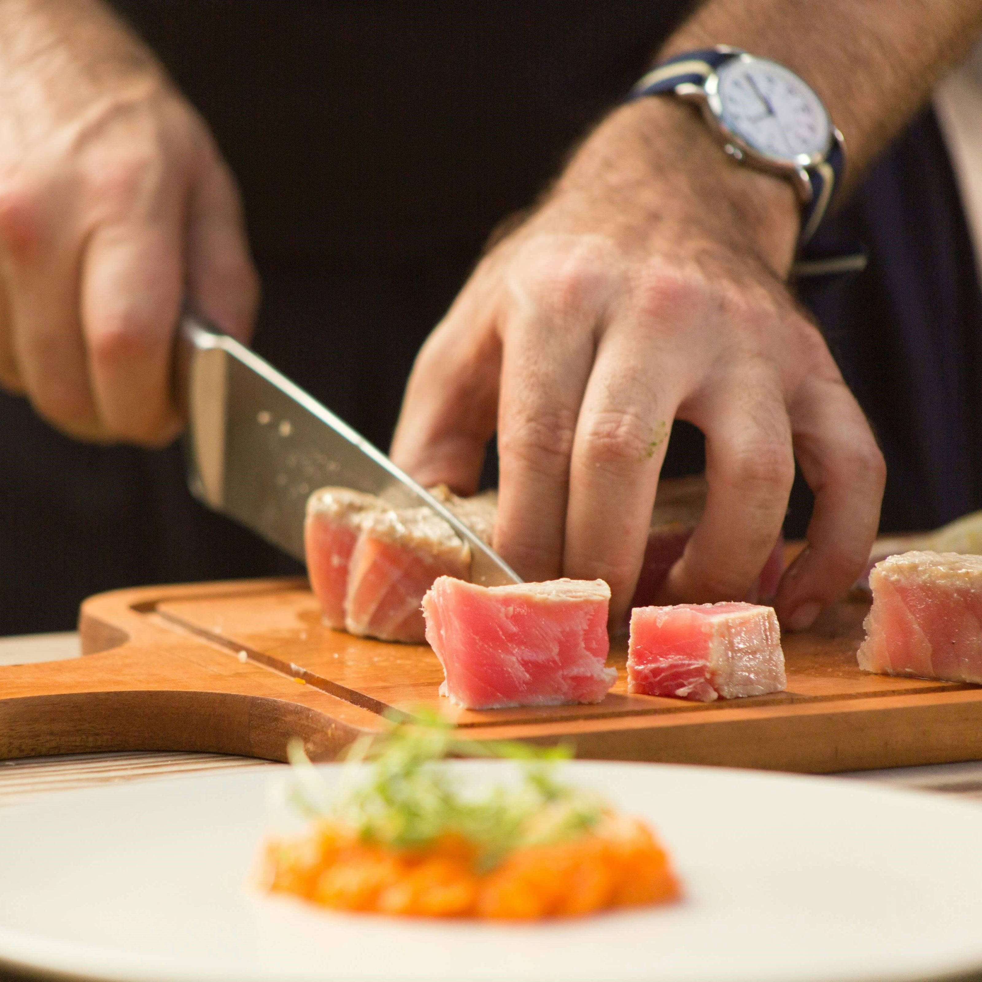 Santoku Messer schneidet mühelos durch frischen Fisch für Sashimi. Santoku Messer: Scharf und präzise für müheloses Schneiden von Fleisch und Fisch.